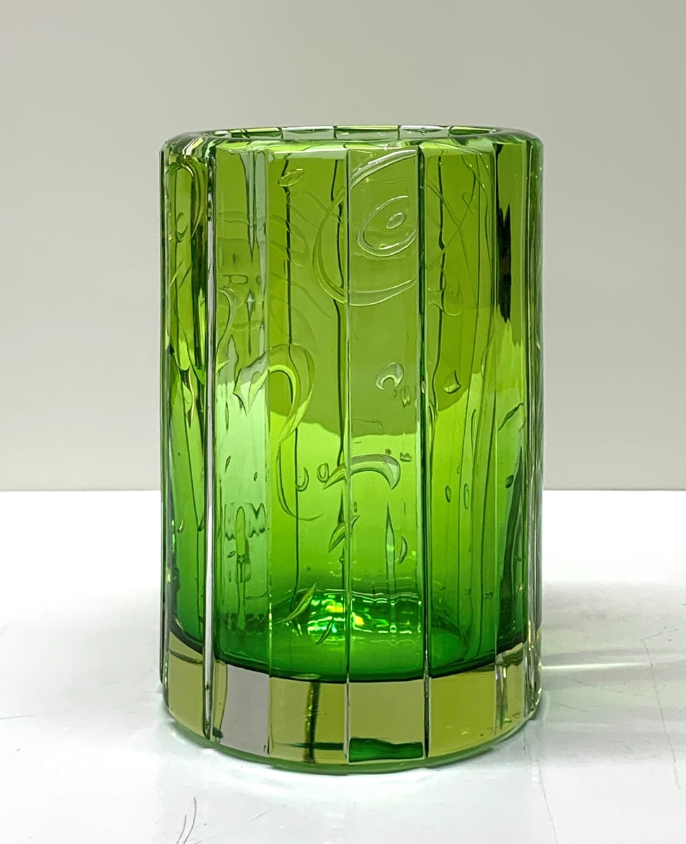 Arielvas av Martti Rytkönen, i grönt underfång med abstrakt motiv. Runt vasen stående breda facetter från botten till mynning. Formgivare Martti Rytkönen.