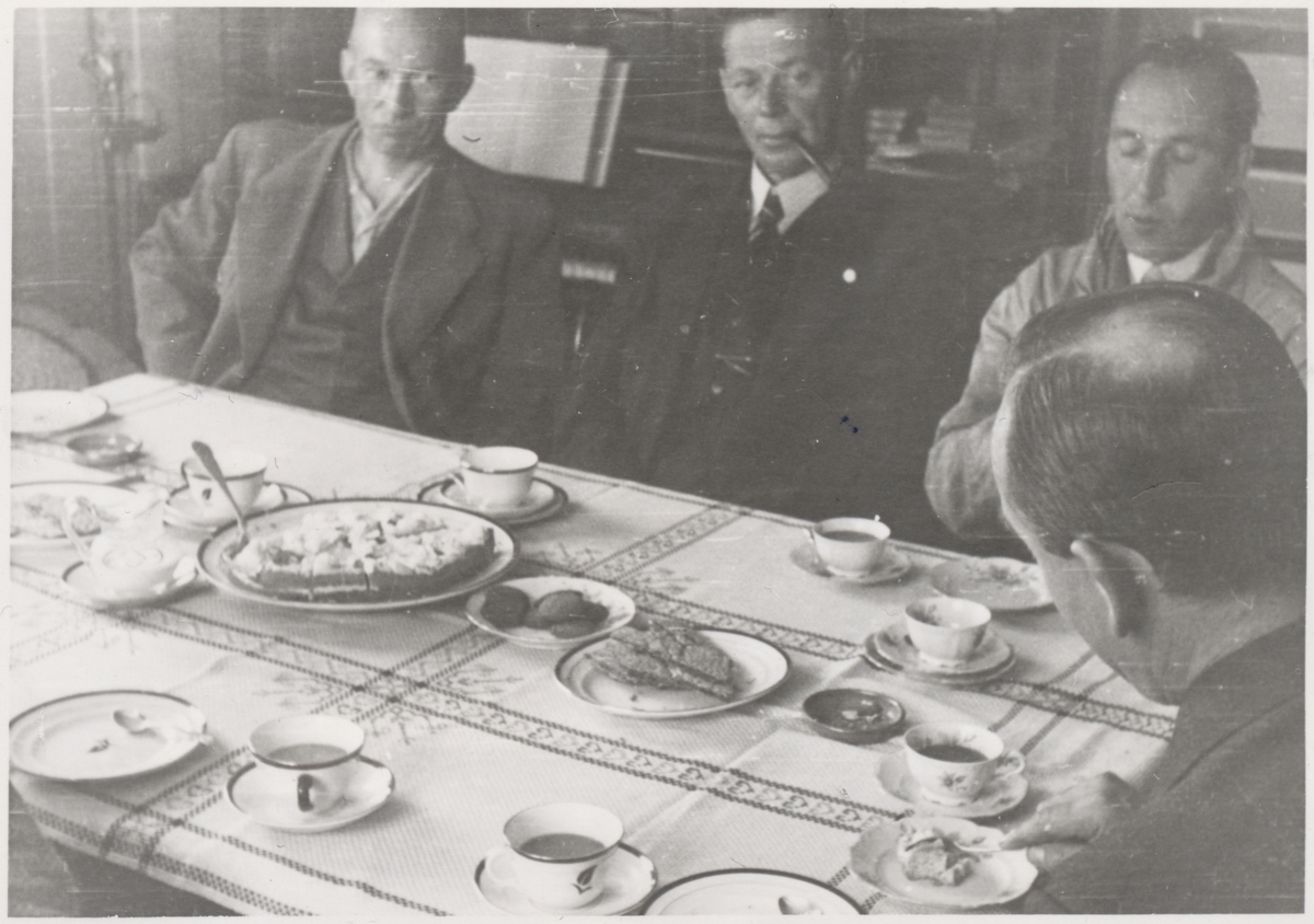 En gruppe av "Trondheimsgislene" på Falstad samlet rundt kaffebordet på Falstad nedre ("Øvergården") på Ekne. Bildet er tatt 9. juni 1942, da de fleste av gislene forlot Falstad.