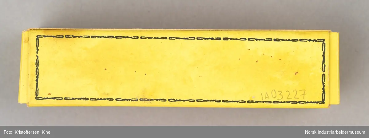 Tube med smertestillende brannsalve i original emballasje. Esken er avlang og gul med sort skrift-
