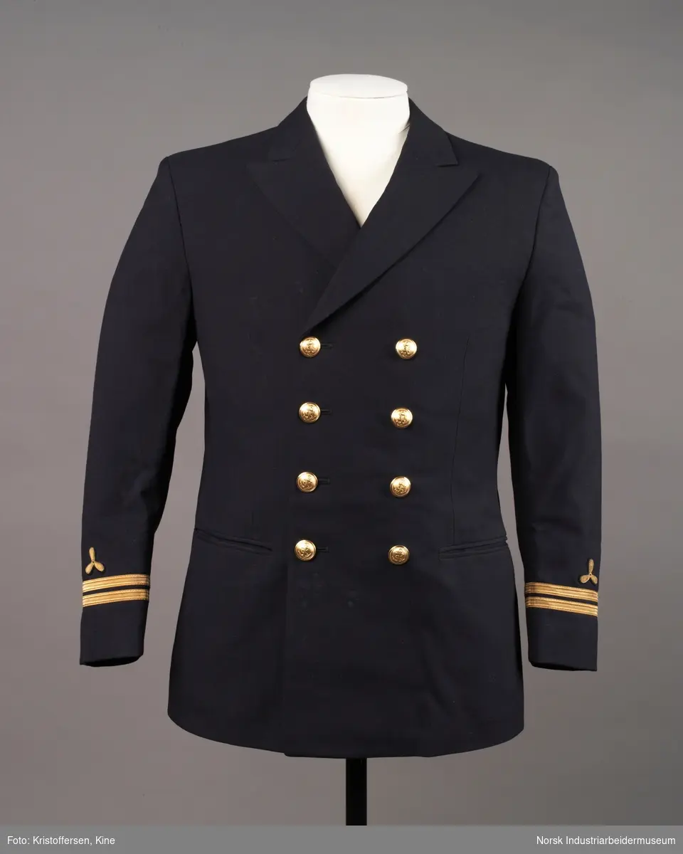 Uniformsjakke til maskinist med åtte gullknapper med ankerlogo. To striper og propellogo i gull på hvert erme.