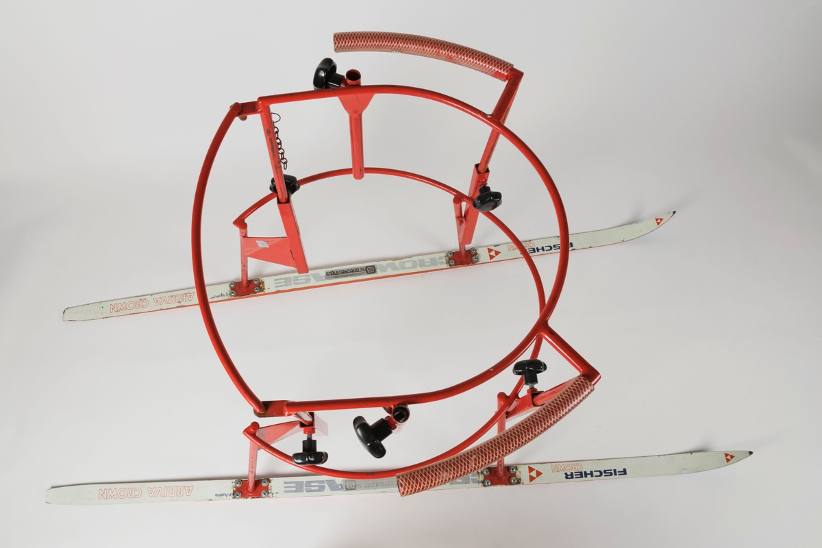 Består av et metallstativ montert på et par ski. Fire skruer/bolter holder hvert av de fire stativbeina fast. Stativet kan reguleres ved hjelp av seks svarte skruknotter. Bakre bøyle/stang på stativet kan løftes av. En kort kjetting henger til venstre for bøylen og har trolig vært festet til den. Håndtakene er polstret med hard gummi.