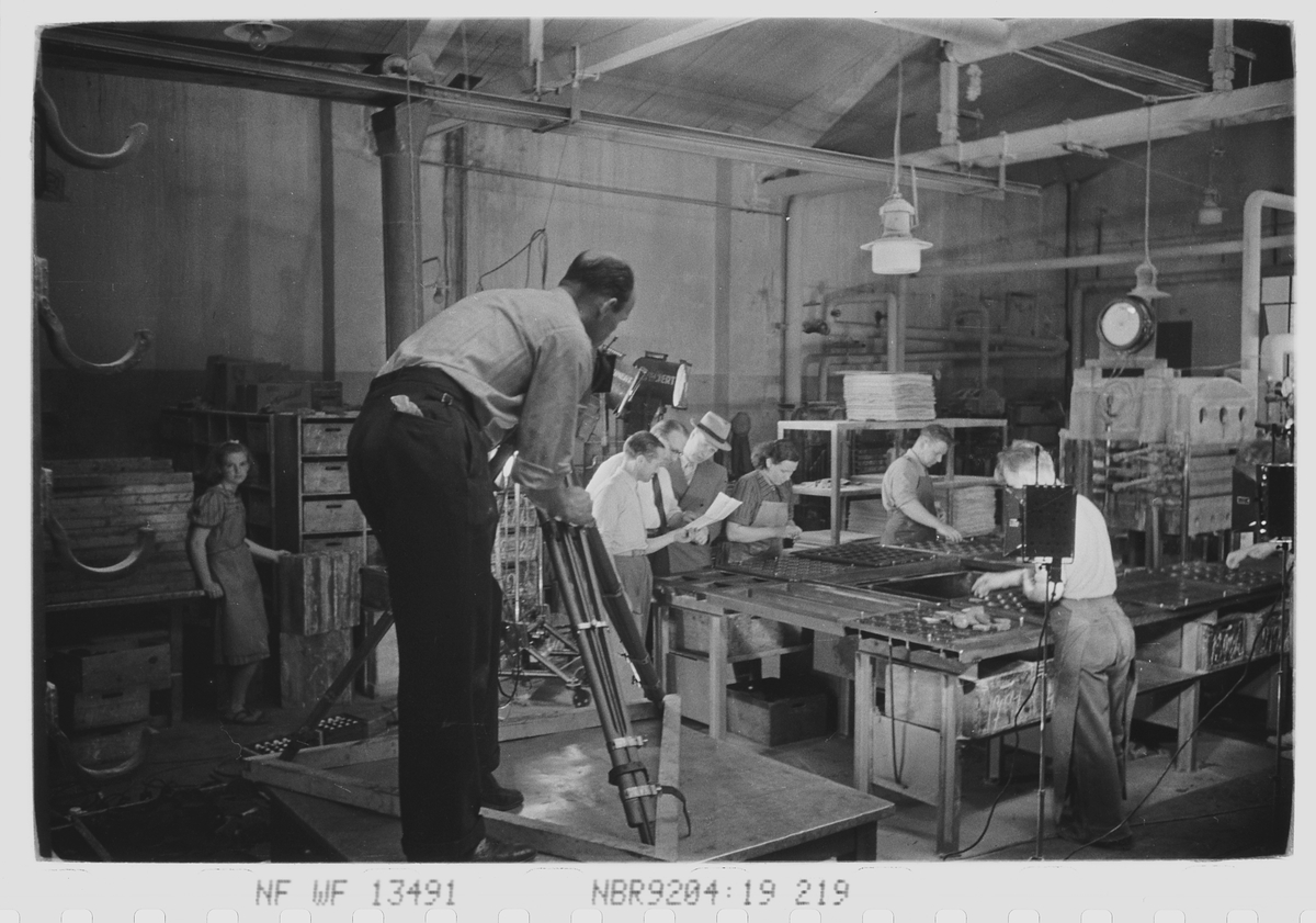 Fotograferting av ansatte i produksjonshallen. Den Norske Kalosje- & Gummivarefabrikk A/S, senere Mjøndalen Gummivarefabrikk, Eiker. Fotografert 1940.