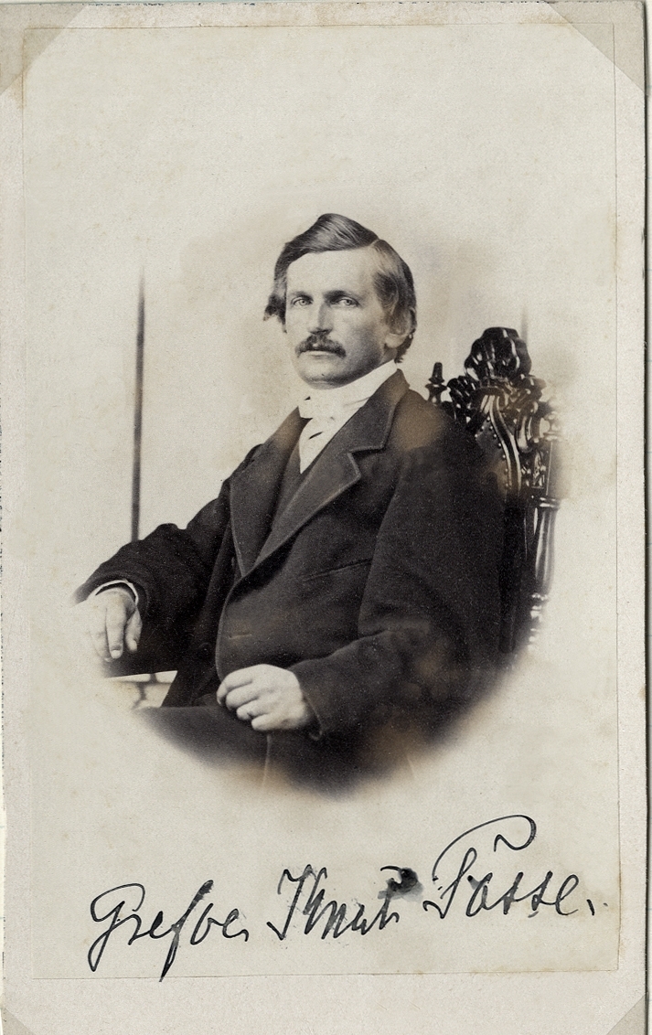 Foto av en man med mustascher, klädd i mörk redingot med väst, stärkkrage och vit fluga. Han sitter på en högryggad stol.
Under fotot text: "Grefve Knut Posse".
Midjebild, halvprofil. Ateljéfoto.