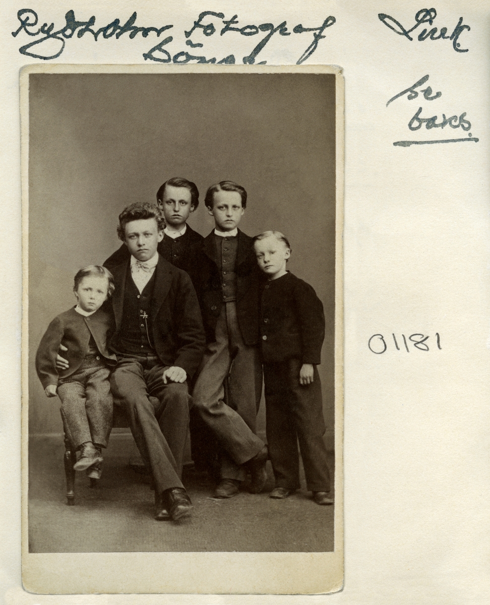 Grupporträtt av fotograf Svante Leonard Rydholms och makan Matilda Sofia Odins söner. I bild sitter äldsta sonen Adolf med yngsta brodern Johan bredvid sig. Intill dem står bröderna Viktor, Axel och Emil.