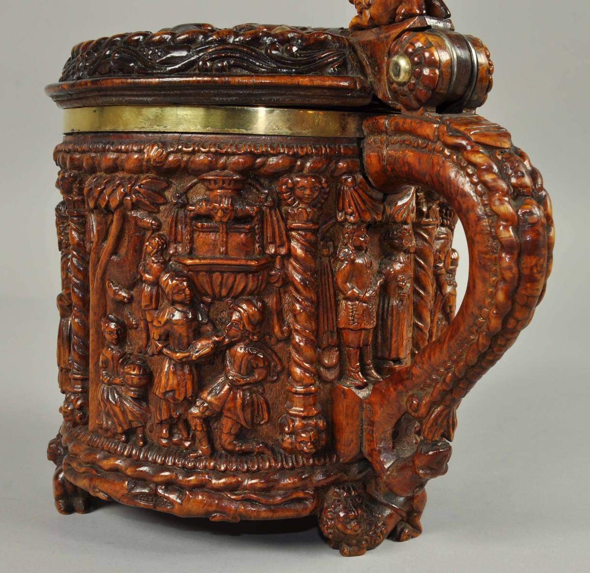 Ølkanne av valbjørk, innvendig foret med forgylt sølv i korpus og lokk. Kannen er skåret ut med scener i dypt relieff, nærmest rundskulptur på sidene, og med flatere relieff og enklere skurd på lokket. 
På lokket er det en framstilling av Syndefallet, med Adam og Eva stående under kunnskapens tre der de strekker seg etter epler, mens slangen snor seg om treets stamme og andre dyr og fugler står rundt omkring. Adam og Eva er nakne, men holder en gren foran skjødet, som om de allerede har spist av eplet. Rundt omkring i dette feltet er det satt inn forgylte nagler. Billedfeltet er omrammet av en tausnoingsbord og utenfor denne en blomsterranke.
Lokket har også en lokknapp som jekk mot håndtaket, formet som en løve. Håndtaket er formet som en slange i underkant, og som en slange med menneskehode på oversiden, eventuelt kan dette tolkes som en havfrue, siden halen ender i en spord.
Kannen har utskårne motiver rundt hele korpus, delt inn i felter med tausnoingsornamenter øverst og nederst og med snodde søyler mellom scenene. Søylene har base og kapitel formet som løvehoder. Det er tre bein formet som liggende kronede løver, og i feltene mellom er det to krokodiller vendt mot hverandre. 
Under håndtaket er det skåret en scene med en mann og en kvinne som står under en baldakin. Kvinnen holder en blomst i den ene hånden, mens mannen holder hennes andre hånd, altså et trolovelse- eller bryllupsbilde. 
Neste scene er Moses, med strålene ut fra pannen, som slår vann av klippen, mens andre mennesker står omkring, neon samler vann i forskjellige kar og bærer bort og en ung mann har lagt seg ned og drikker fra vannstrømmen.
Neste scene viser Moses stående med lovens tavler. Han har stråler fra pannen, og er plassert i en nisje.
Neste scene er Kongenes tilbedelse, der Maria sitter med Jesubarnet på fanget, mens Josef står bakenfor og lener seg på tømmermannsøksen. Foran dem er de hellige tre konger som bærer gaver til barnet, to står og en kneler.
Neste scene er Aron, Moses bror, som var den første yppersteprest. Han er kledd i yppersteprestens drakt slik den er beskrevet i Bibelen med bjeller og granatepler, mens han holder et røkelseskar. han er som Moses plassert i en nisje.
Siste scene er Isaks frierferd, der Abrahams tjener er sendt ut for å finne en kone til Isak. Rebekka har hentet vann fra brønnen, som er framstilt bak i scenen som en fontene der vann strømmer ut gjennom fire løvehoder. Tjeneren får drikke av hennes urne, mens en annen pike sitter med et kar og en tjener står og passer flere kameler i bakgrunnen.
Under kannen er det en skrue og mutter som fester sølvforingen til trekannen. En innskrift er grovt skåret inn, men er vanskelig tydbar, men synes å være tre bokstaver, hvorav de første synes å være O ug T eller I. Lokket er foret, og med en gravert innskrift på innsiden, sammen med kongemonogrammet C7.