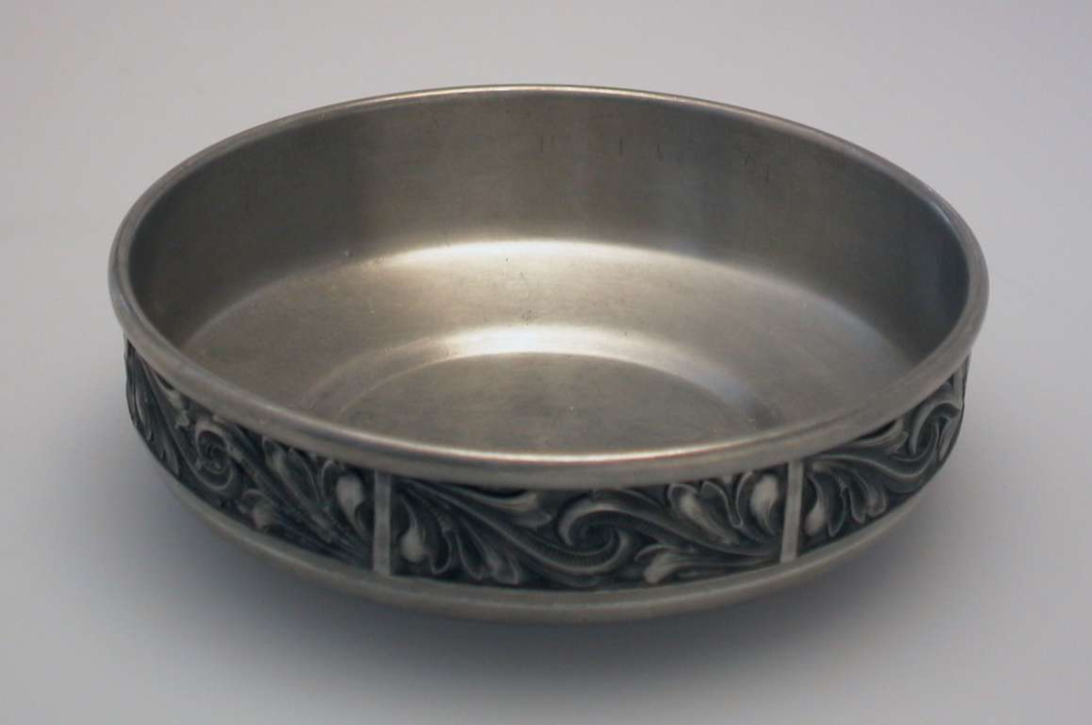 Bolle i tinn med bladranke rundt kanten.