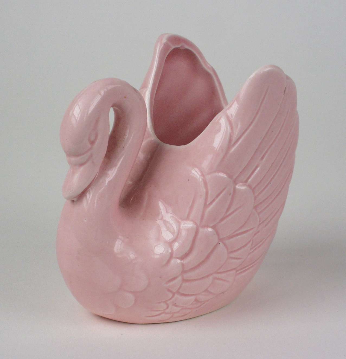 Rosa svane i keramikk.