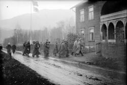 Gruppe med menn i uniform, marsjerende inn i Tromsa (Tromsne