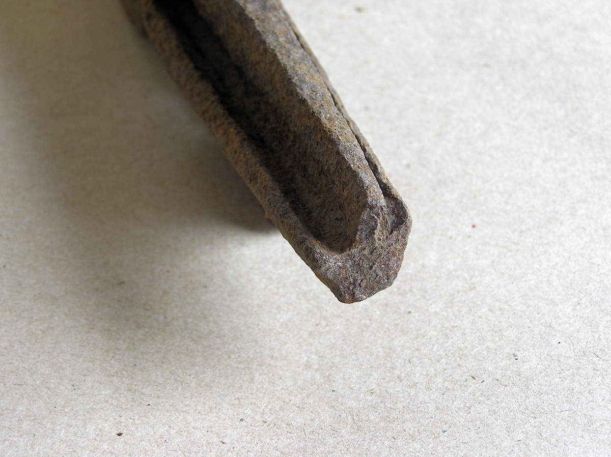 Smidd jernstykke til bruk ved smiing av merkeøks. Merket ble formet rundt stempelet. Stempeldel og håndtak i ett. Noe rust.