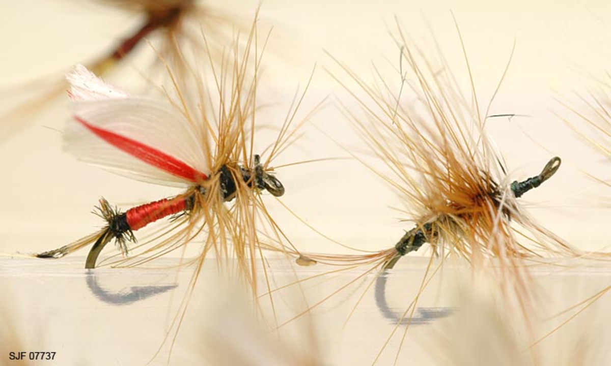 Tilstand: I forbindelse med omfototgrafering høsten 2002, oppdaget OT Ljøstad at enkelte av fluene i denne esken var totalt ødelagt av møllangrep.  Problemet må ses i sammenheng med at materialet har vært oppbevart i magasin C, der temperaturforholdene har passet møllen godt.  Fluene vil nå bli reingjort og flyttet til kjølerommet. 

Boksen inneholder ialt 76 fluer alle ant. tørrfluer. 2 stk har ekstra lange bein ant. navn: Daddy long legg. Tørrfluene virker på den måten at de flyter oppå vannet. Giveren har skrevet ei bok som heter "Isfiske" sammen med Knut Rom, boka ble utgitt i 1972. Giverens far var en ivrig sportsfisker og er gitt tittelen "Den fullendte sportsfisker". 