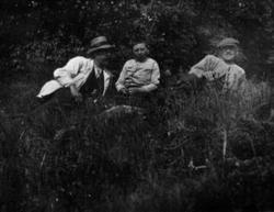 Tre menn sitter på bakken. Fra venstre er Sigvart Ulven med 