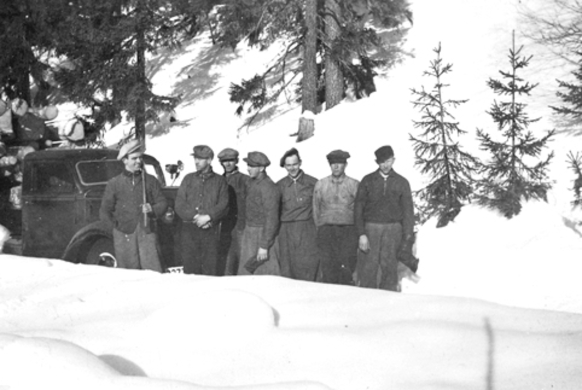 Gruppe skogsarbeidere foran lastebil ved Basarud, Furnes Almenning. Fra venstre er Asbjørn Havik, Einar Jevanord, Hjalmar Havik, Alf Nordengen, Asbjørn Rønningen, Magne Solheim, Ole Røset.