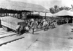 Mosambik 1914. Lossing av store kasser i tre på et havneområ