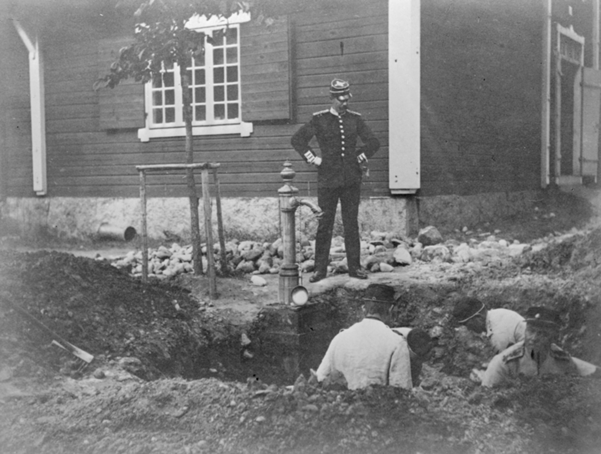 Reparation av vattenledning vid Malmen ca 1890. Personer i arbete i grävd grop.