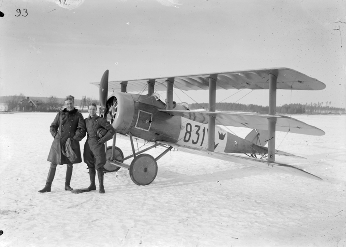 Två män vid flygplan Triplanet märkt 831, på Malmen, vintertid.