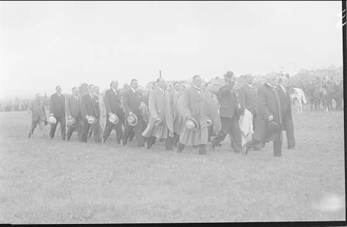 Deltagarna i kamratdagen 7 juni 1937 marscherar ut till uppställningsplatsen på fältet söder om kasern för att lämna av till sekundchefen. I bakgrunden den beridna musikkåren med vit pukhäst. 