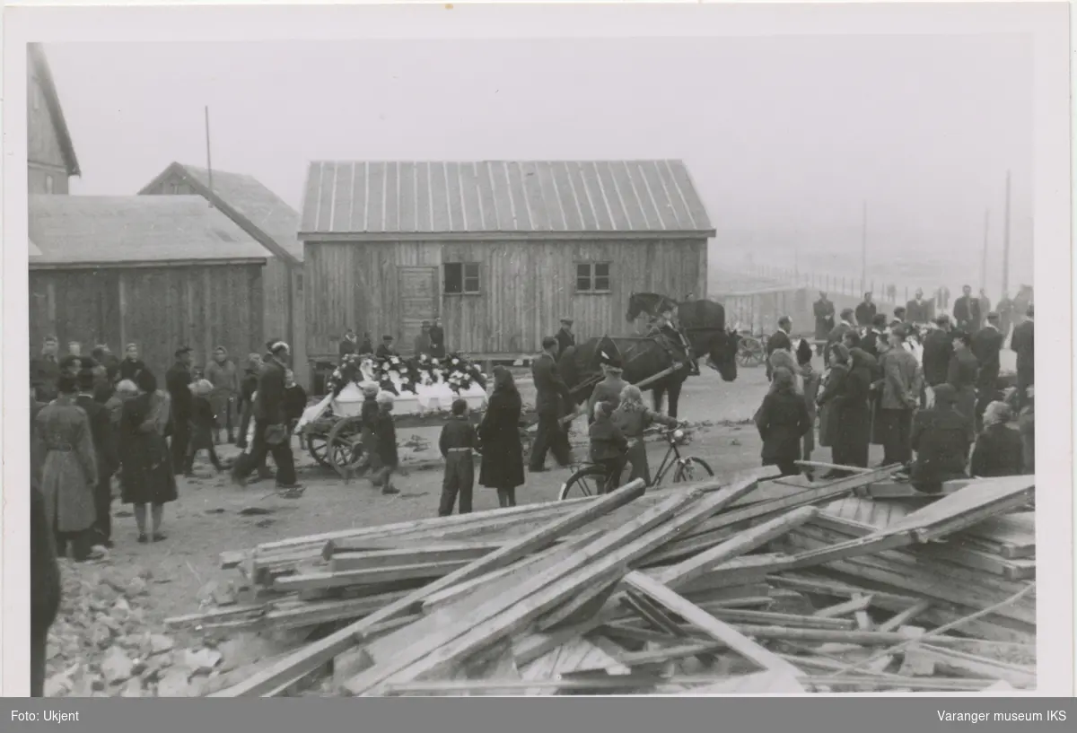 Et gravfølge passerer frelsesarmebrakka i Vardø, 1946. Kisten blir fraktet med hestevogn
