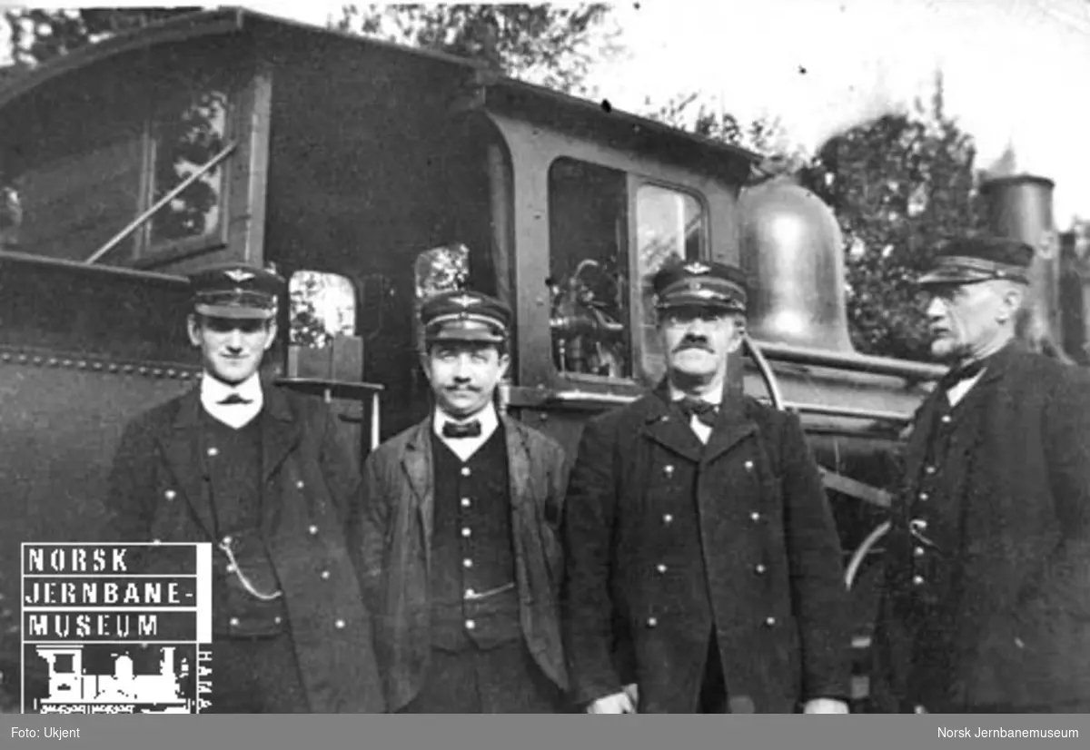 Fire menn opstilt foran et damplokomotiv av type 9a i Moss