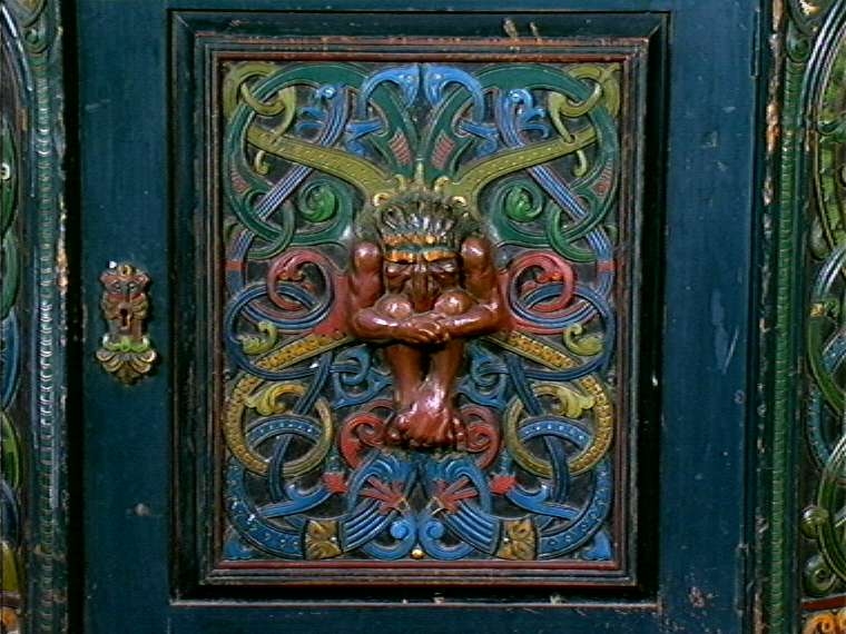 Skåret av treskjæreren Lars Kinsarvik (1846-1925), som utviklet sin særegne variant av drakestilen. Kinsarvik drev egen treskjærerskole, og var fra slutten av 1880-årene lærer ved Kristiania Kunstindustrimuseum.