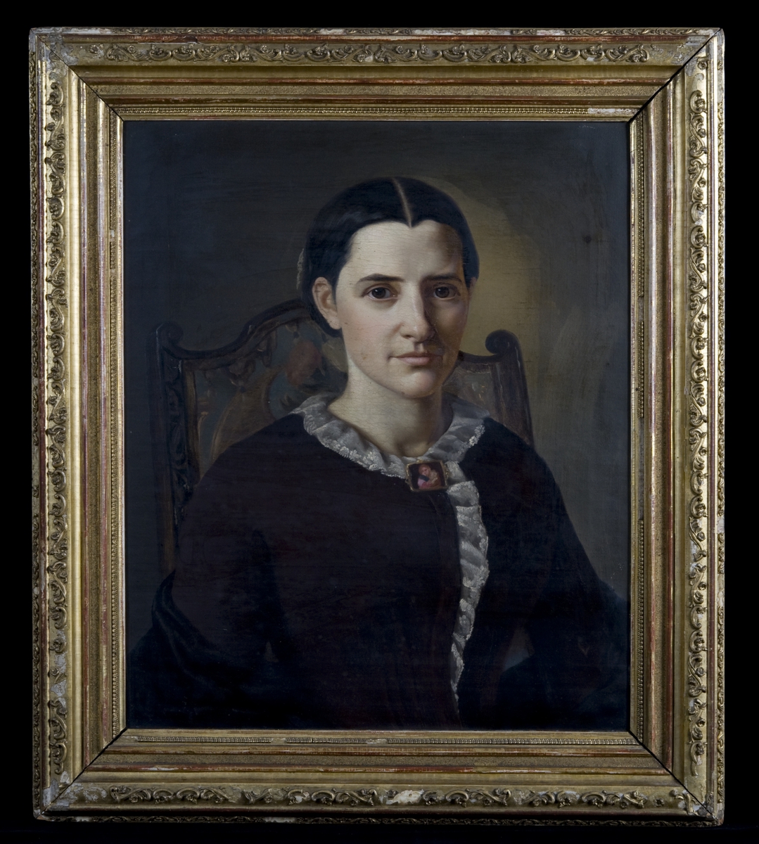 Brystportrett av kvinne i svart kjole med hvit rysjekrage.