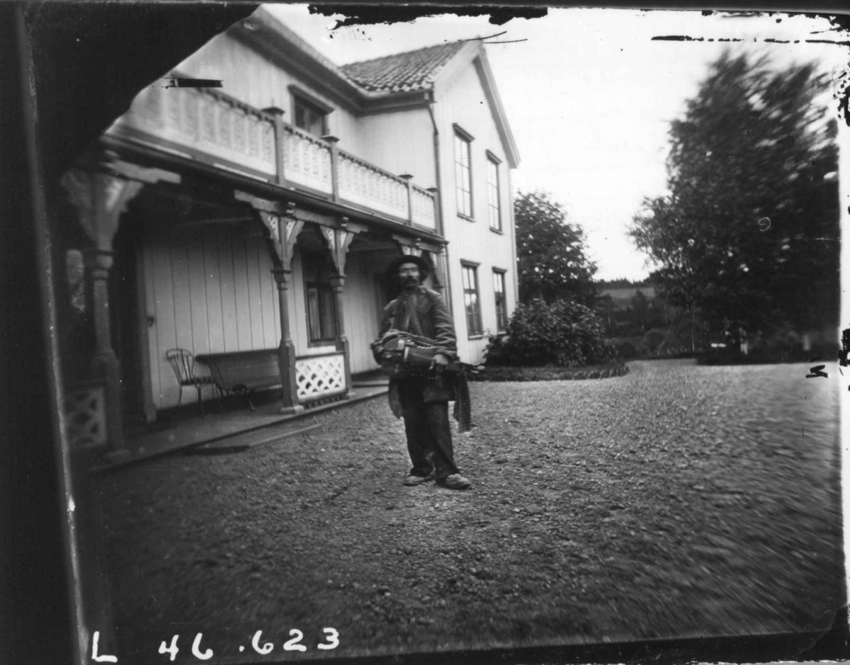 Portrett, mann foran hovedbygningen.
Fra portrettserie av personer som bodde på eller besøkte Dal gård, Ullensaker, fotografert av gårdens eier, kammerherre Fredrik Emil Faye (1844-1903) i årene 1875-1900.