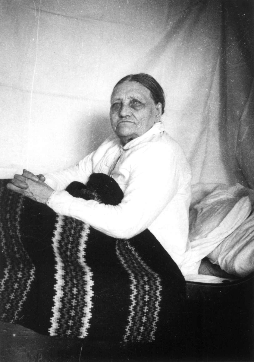 Fru Åselina Eiken sitter i sengen sin. Eiken, Hægesbostad, Vest-Agder 1937.