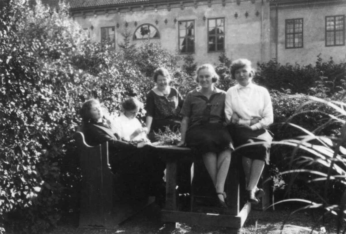 Noen av de kvinnelige ansatte er samlet i prestegårdshagen i 1929. Bybygningen, bygning nr. 311 på Norsk Folkemuseum sees i bakgrunnen.