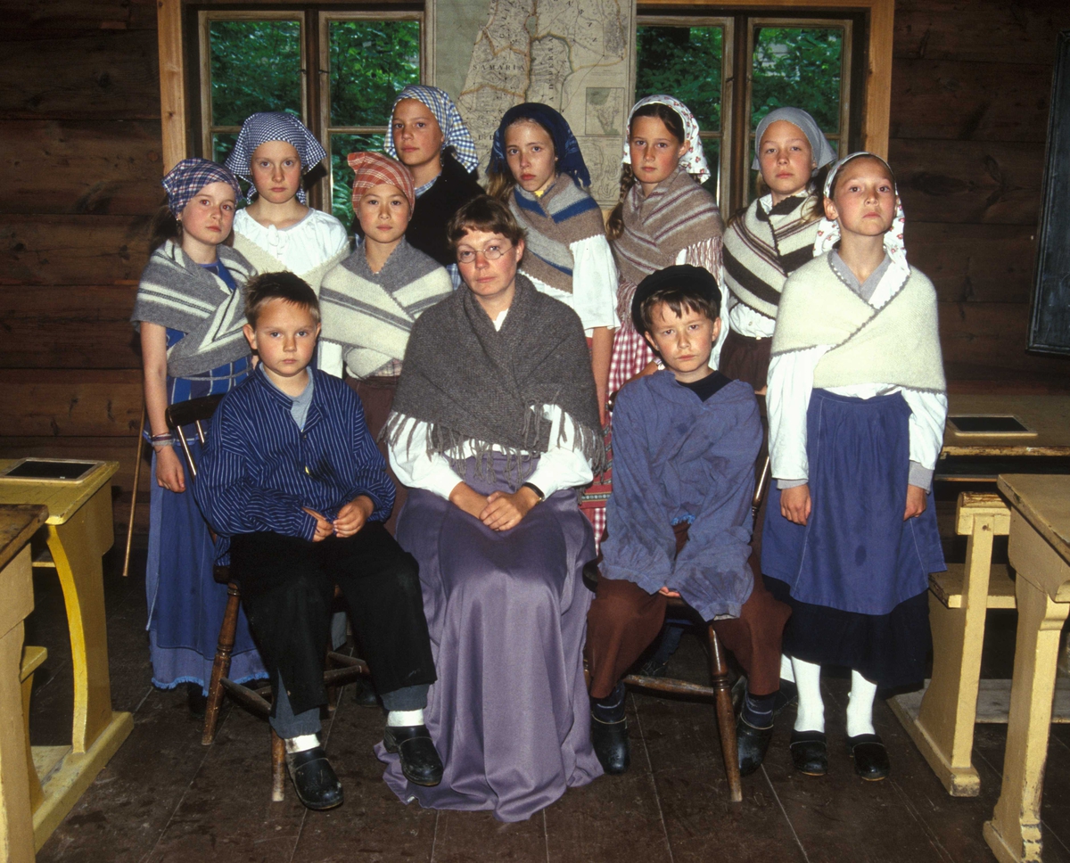 Levendegjøring på museum.
Ferieskolen juni 2002. Klassebilde. I Skolestua bygning nr.196 på Norsk Folkemuseum.