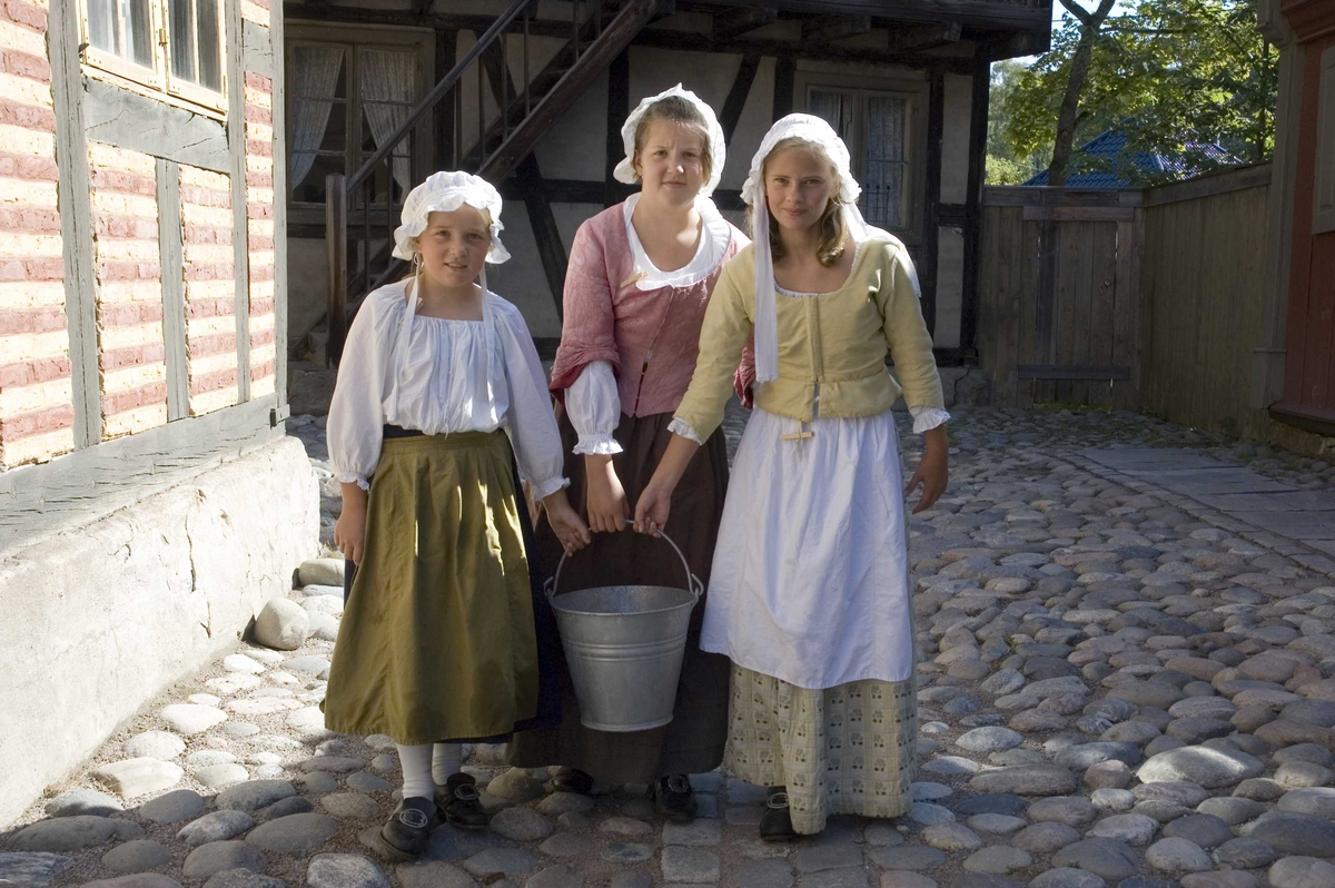 Levendegjøring på museum.
Ferieskolen uke 31 i 2006. Tre jenter som bærer vann.
Norsk Folkemuseum, Bygdøy.
