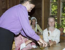 Levendegjøring på museum.Ferieskolen uke 31. Elevene får tr