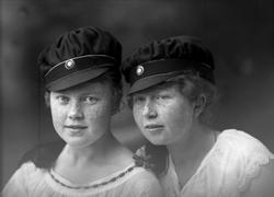 Gruppeportrett, to jenter med studenterluer. Student Magg Sø