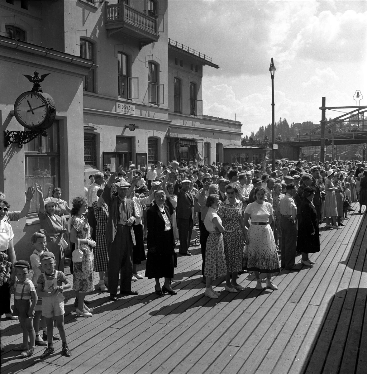 Mennesker på jernbanestasjon. Eidsvoll stasjon, 15.06.1953. NSB. Jernbanen Lillestrøm - Hamar. Første elektriske tog