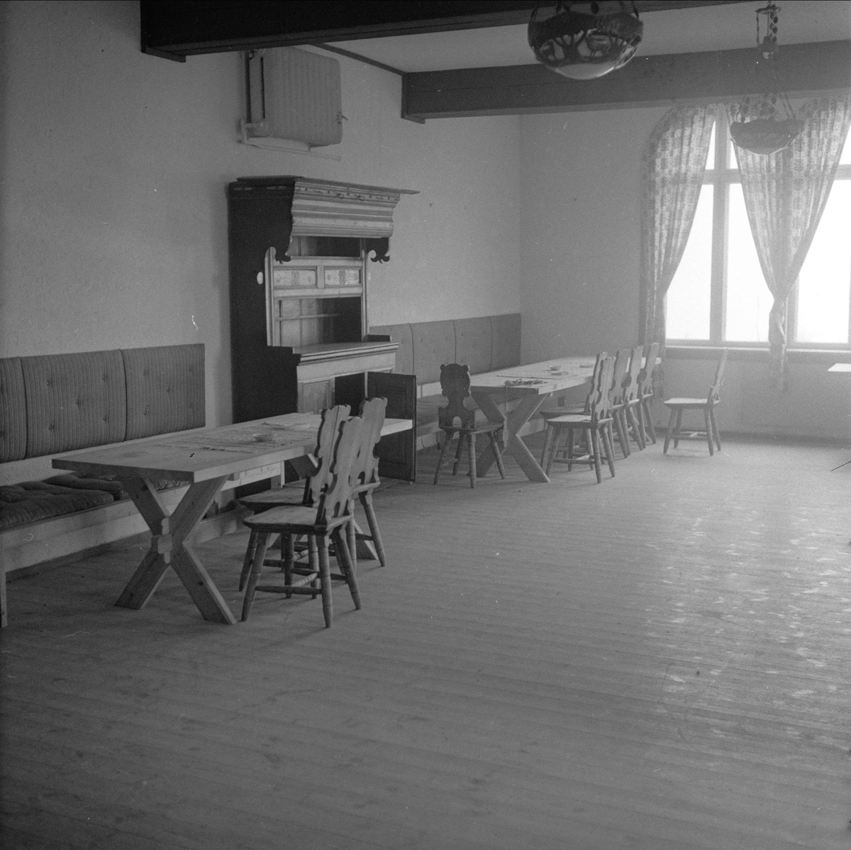 Breidablikk turisthotell, Sør-Aurdal, mai 1957. Interiør med bord, benker og skap.