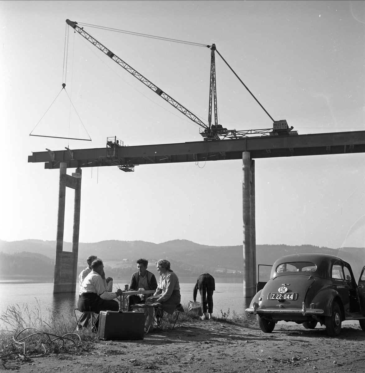 Minnesund, Akershus, september 1958. Minnesundbrua. Bil, mennesker og brubygging. Nordsida.