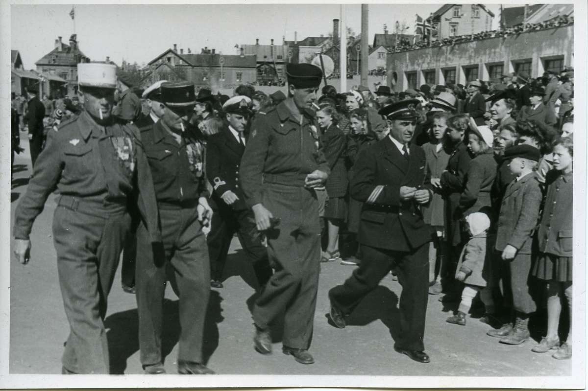 Militærparade på Torve etter 2. verdenskrigt. Franske soldater. Torvhallen til h. Merk marineoffiseren. Bransjeoffiser med "kofferthåndtak" i stedet for komandoløkke.