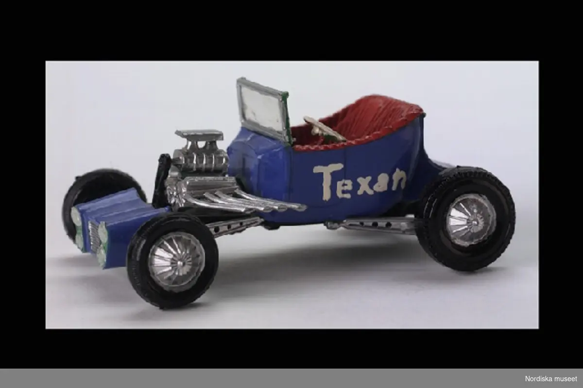 Inventering Sesam 1996-1999:
L 11 cm
B 7 cm
H 5 cm
Leksaksbil av blåmålad plast, öppen tvåsitsig modell. Sätet rödmålat. Vindruta, Öppet motorrum. Fyta svarta hjul (ej rörliga). Målat med vitt på ena långsidan "Texan".
Bilen byggd av en byggsats och är av så kallad "Hot Rod"-typ.
"Peter har gjort den själv och själv köpt den för 1 1/2 år sedan". Se vidare uppteckning med Peter Sivert gjord 22/5 1978.
Bilaga
SE 1981 [=Sigrid Eklund]
Leif Wallin 1996