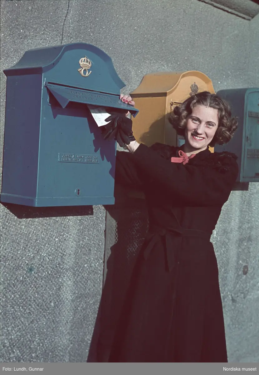 Kvinna vid postlådor