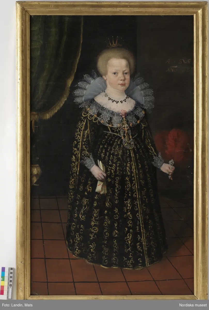 Tavla, porträtt. Drottning Christina (överstruket), okänd flicka, olja på duk. Text: "ANO 1627". Stående Christina, född 1626, iklädd prinsesskrona och lång, urringad brokadklänning. Profilerad, förgylld träram.