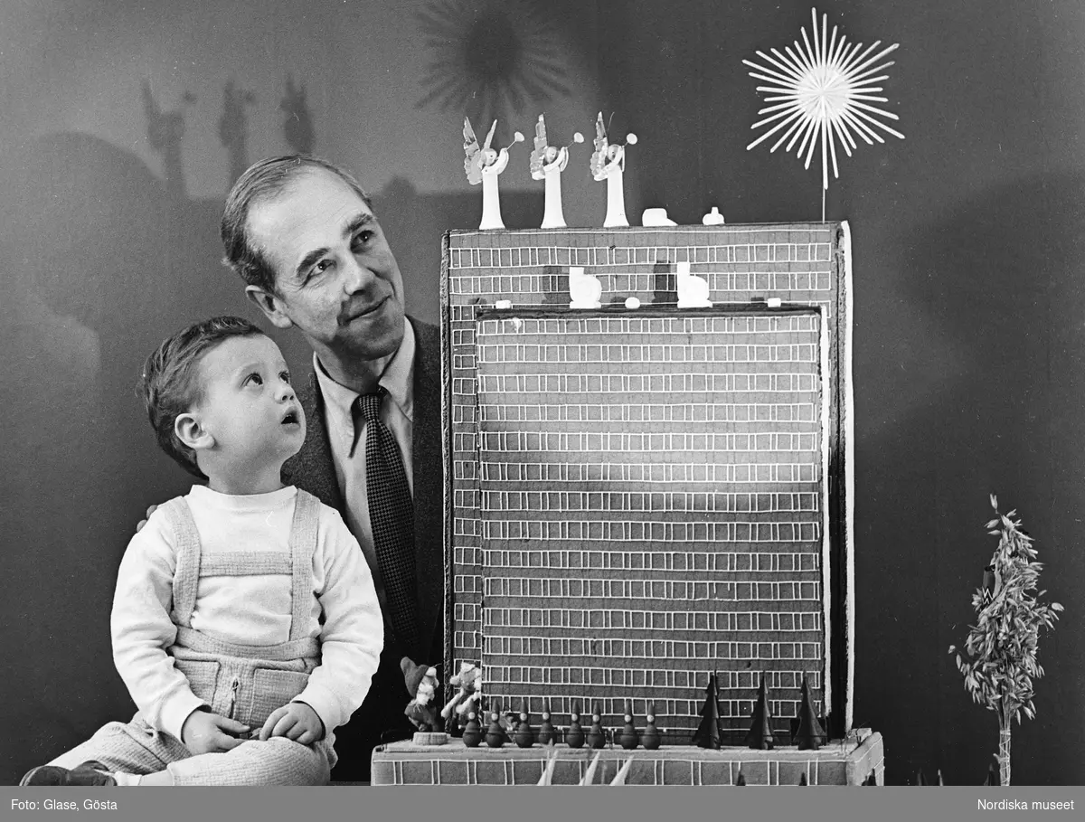 En man och ett barn med pepparkakshus i modernistisk stil