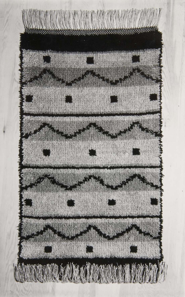 Tre svartvita fotografier föreställande mattor. Fotografierna är klistrade på 22 x 27 cm stora bruna kartongblad.