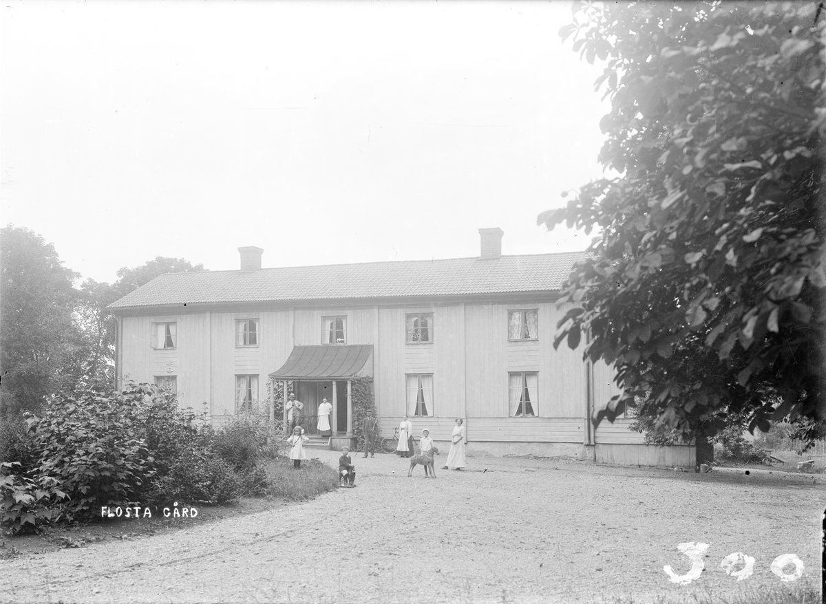 Kvinnor, barn och man framför huvudbyggnaden på Flosta säteri, Altuna socken, Uppland 1916