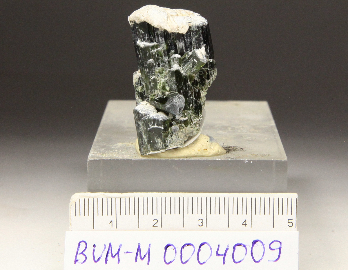 Diopsid, små edle grønne krystaller, med hatt med hvit aktinolittasbest.