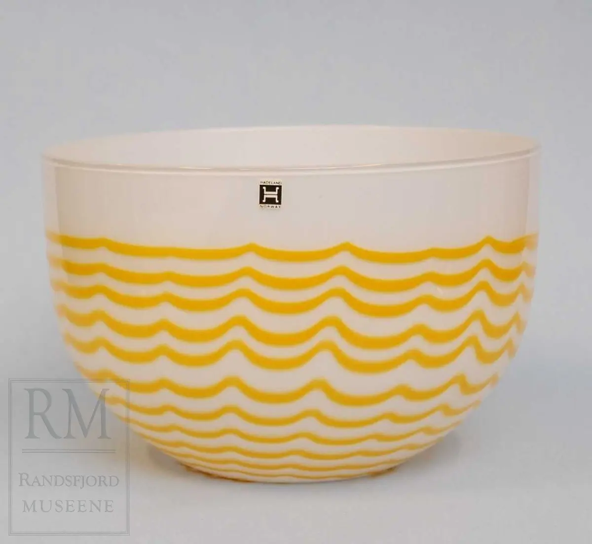 Hvit bolle, med gule bølgelinjer. 
Grå/svart orginalemballasje. 