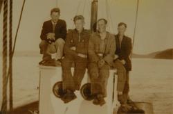 Fire menn poserer på styrhuset på en fiskebåt