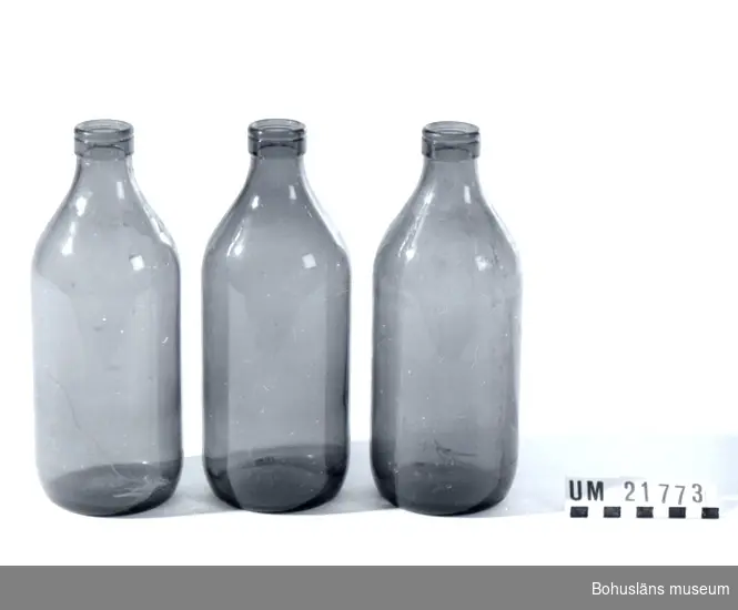 Förpackning för mjölk.
Flaskorna märkta i botten med följande text: "1 Lit (L) ll 64". De två andra flaskorna är märkta med följande text: "1 Lit (L) 9.64".
