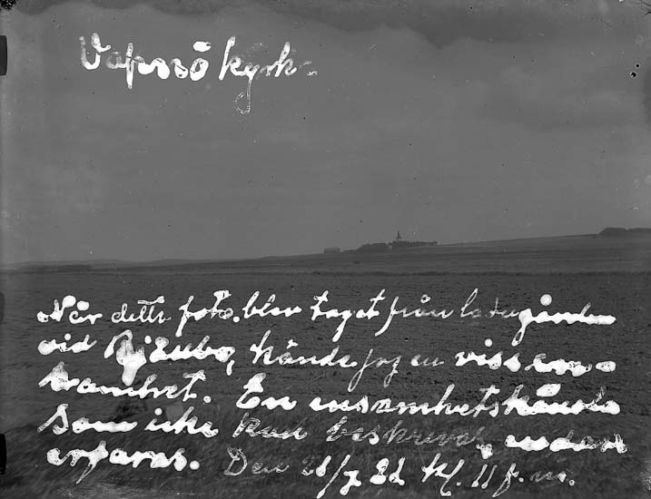 Foto över slätten runt Vapnö Kyrka med en text inristad i glasplåten(negativet) av fotografen