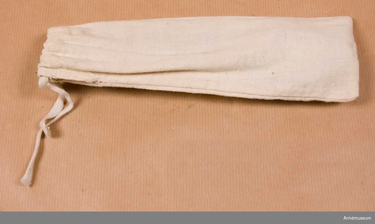 Grupp C I
Av vitt bomullstyg med snören för att binda fast påsen. Rymmer gaffel, kniv och sked.

Samhörande nr är AM.20759-62