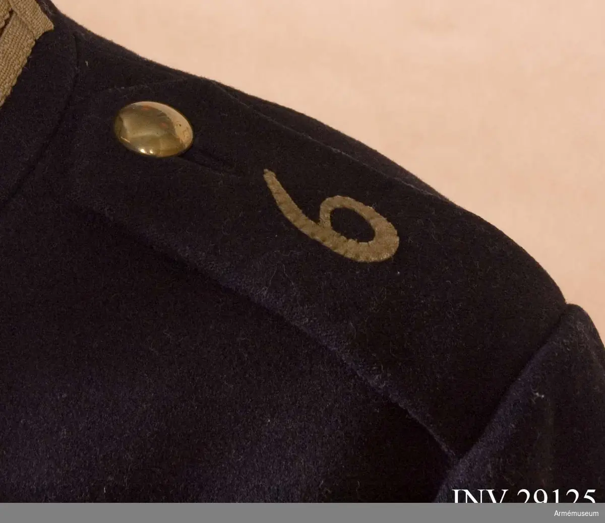 Axelklaffar av mörkblått kläde med regementsnummer, en påsytt 6:a i gult kläde.