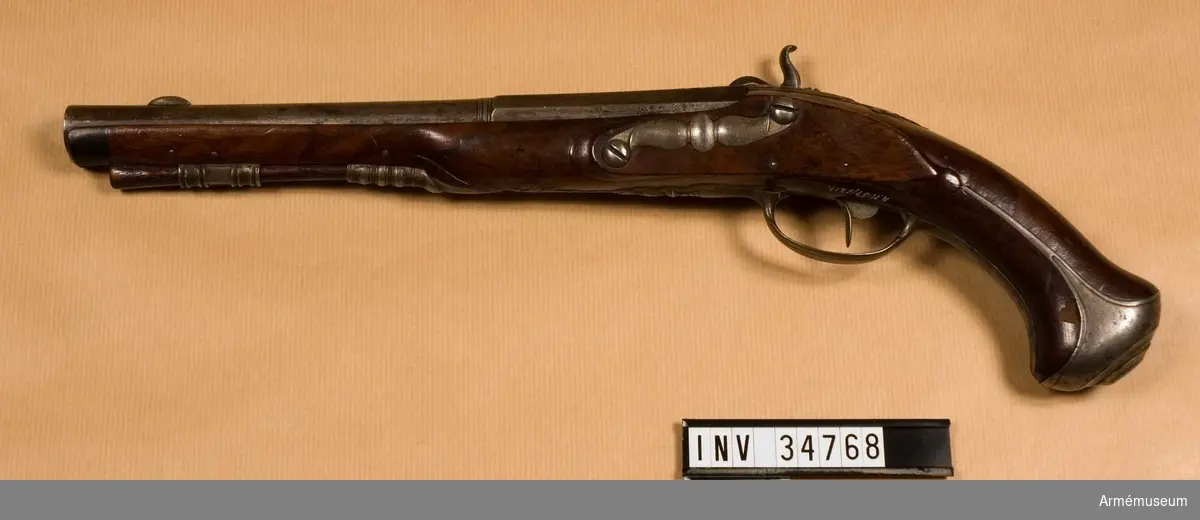 Grupp E III a.

Flintlåspistol från 1700-talets senare hälft, förändrad til slaglås.

Pistolens pipor är brungjorda. Även övriga beslag har haft en gråaktig yta, som nu är delvis förstörd rost. Laddstock av trä. På låsblecket står: Örebro. Tumgreppet på hanen bräckt.