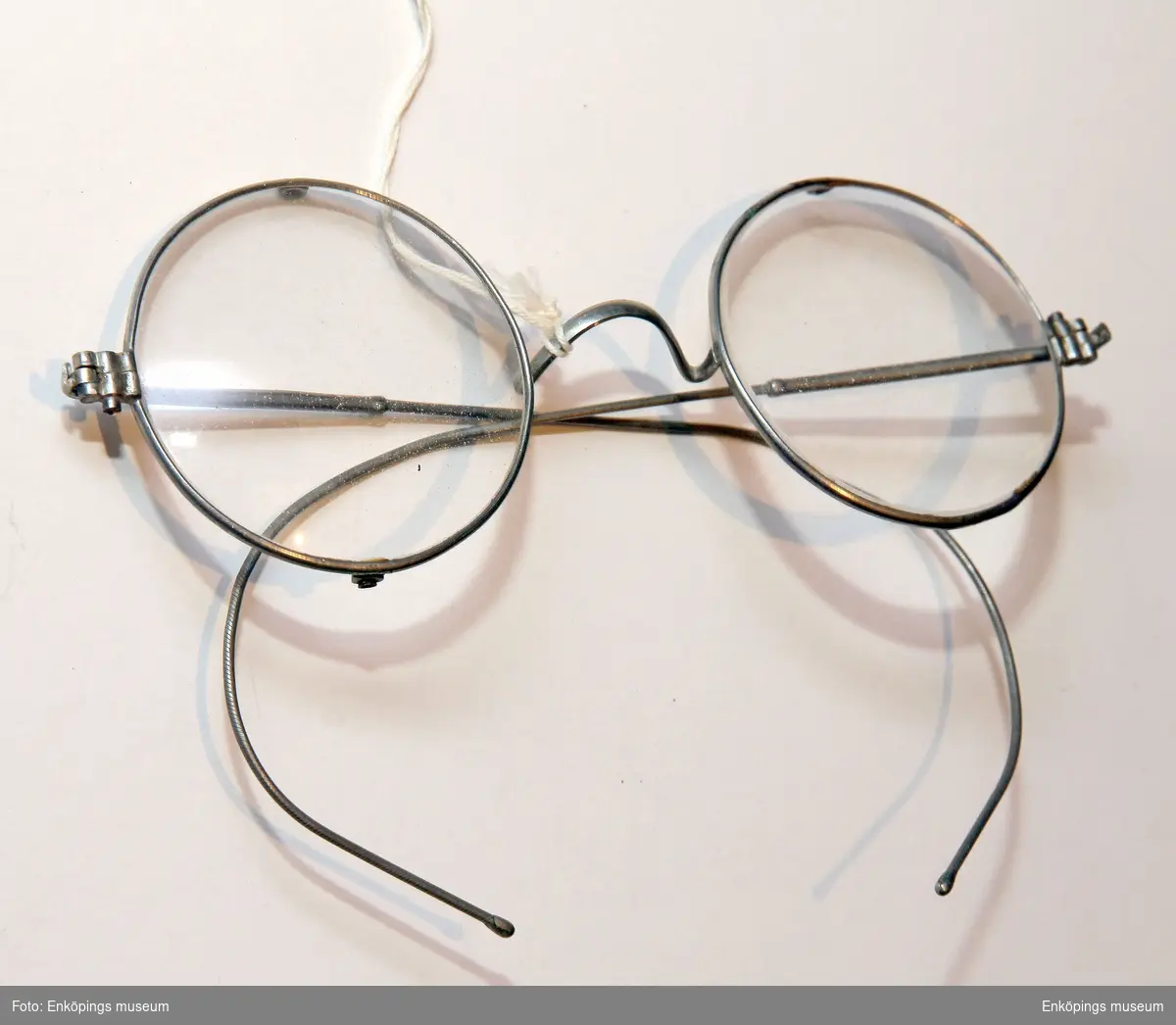 Glasögon med runda glas och stålbågar.